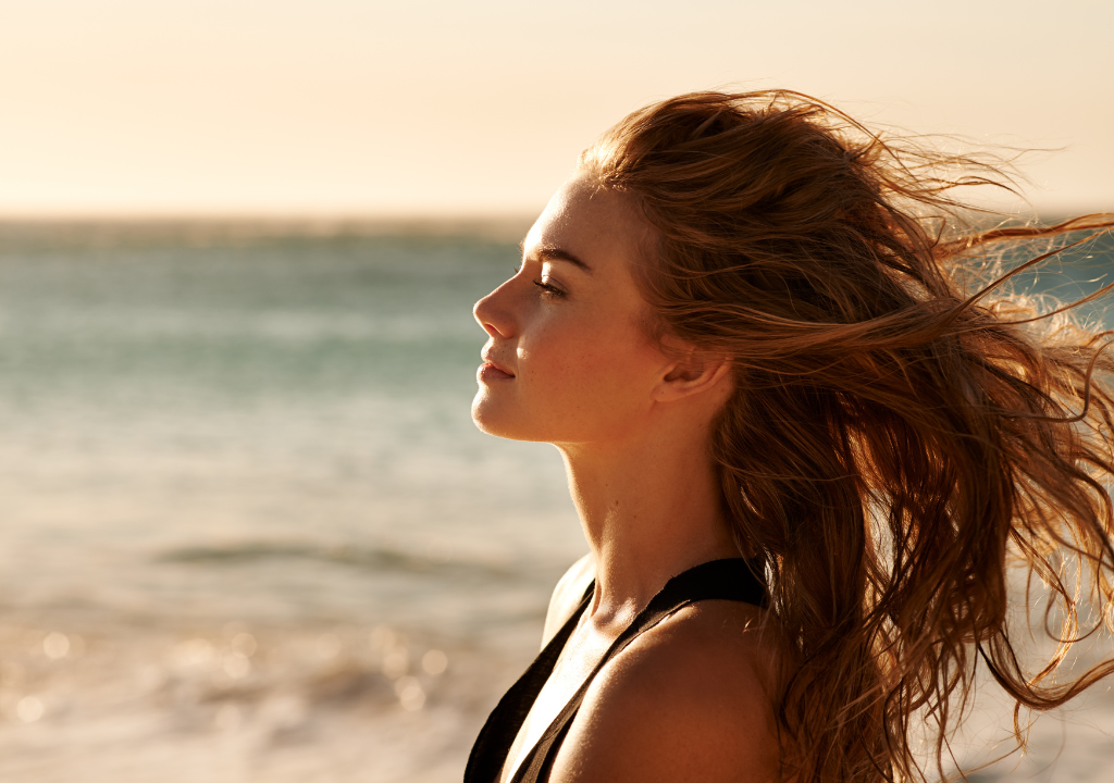 Woman on beach with hair blowing in the wind