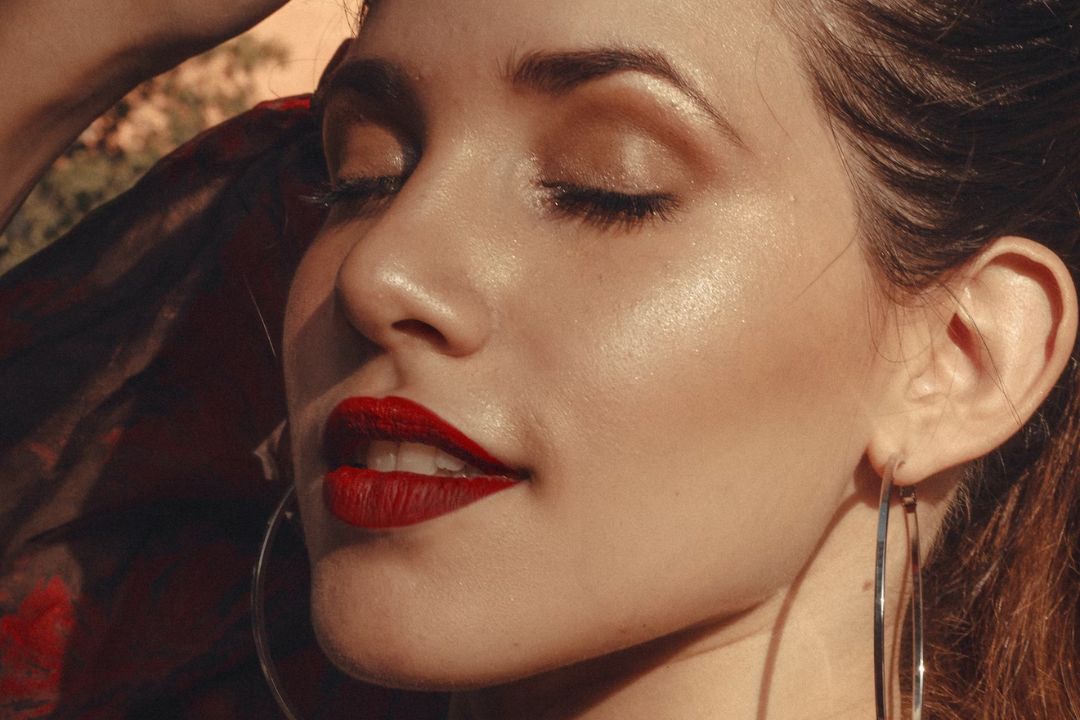 close up of woman's face waring gold eyeshadow and red lipstick