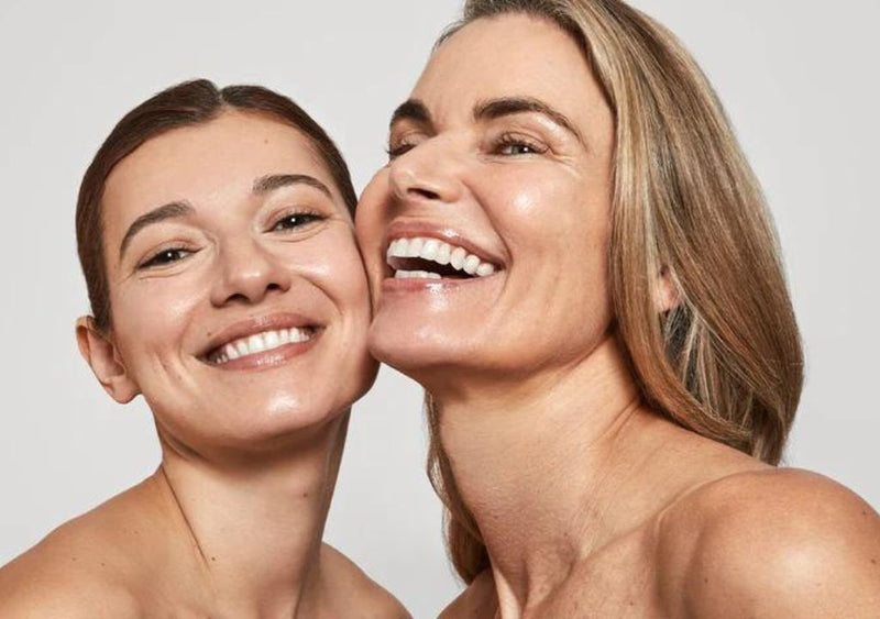 Two women with radiant skin smiling