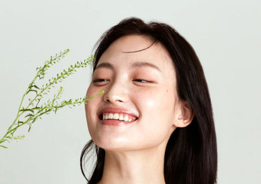 Smiling lady holding a flower near her face