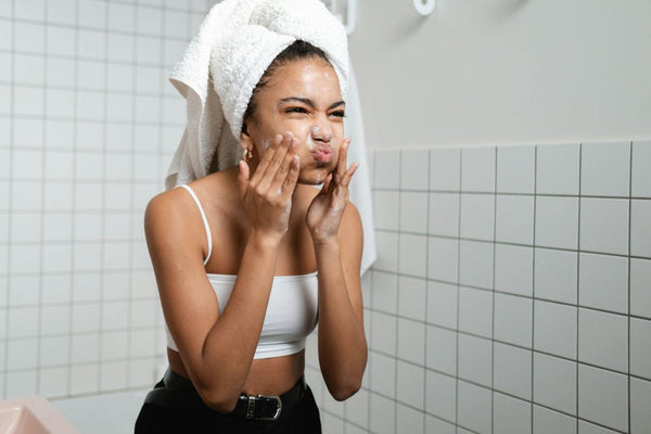 woman doing her skincare routine in the mirror