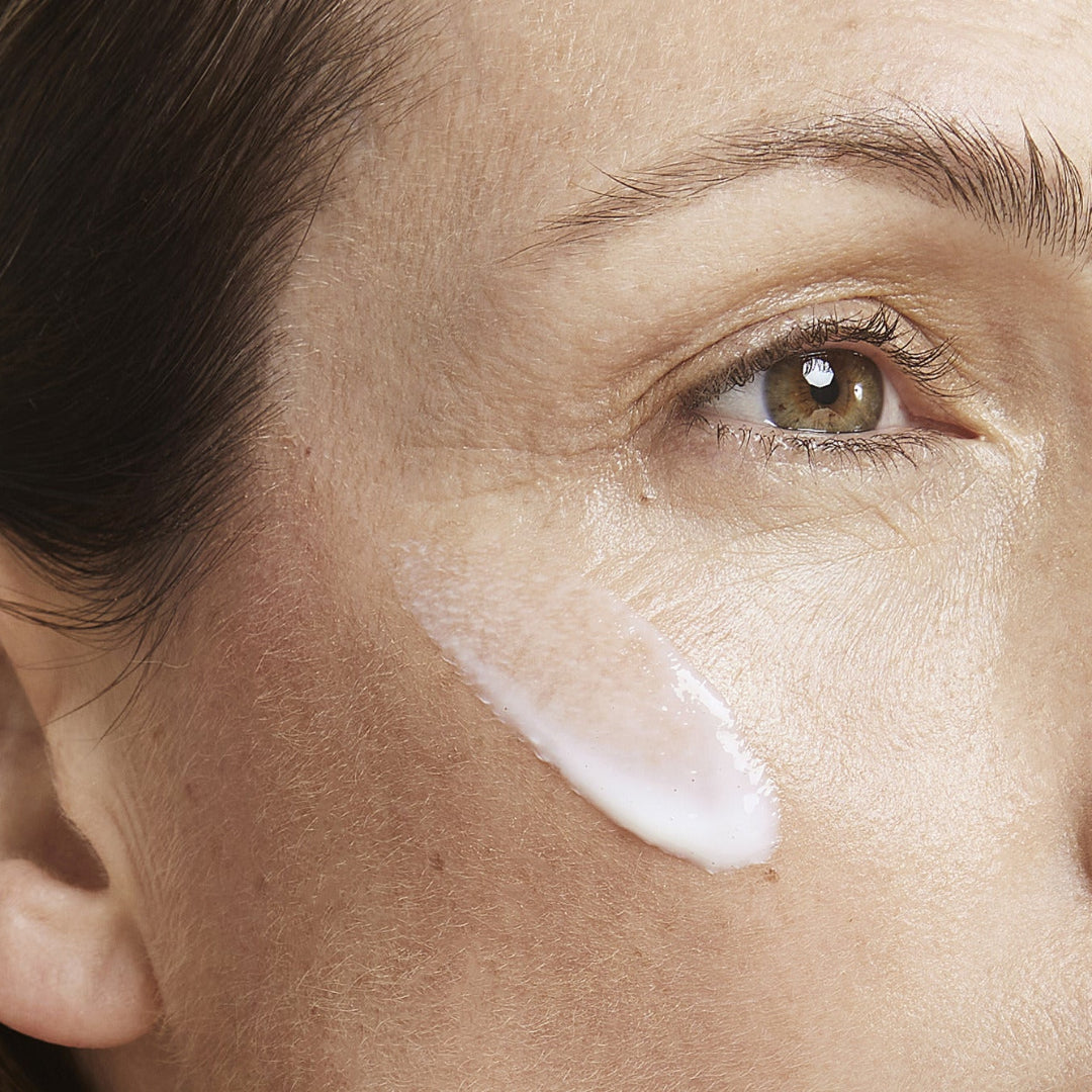 a close up of a women with cleanse applied to her cheek