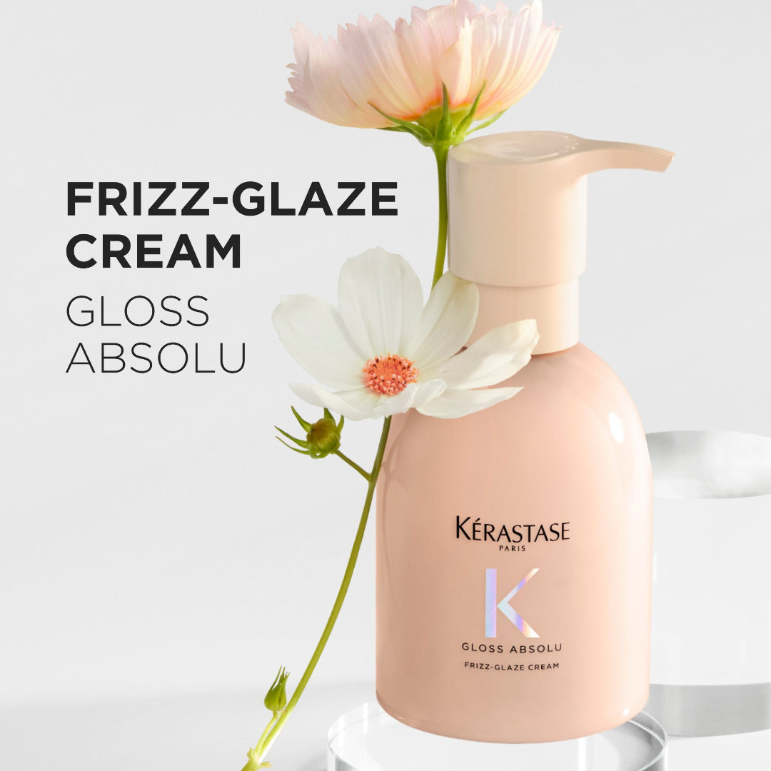 Kérastase Frizz-Glaze Cream bottle with flowers on a light background