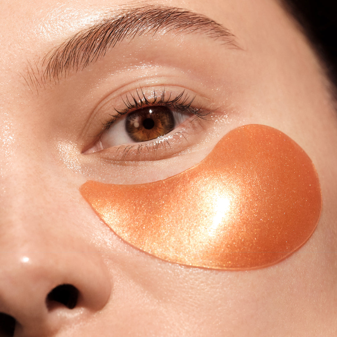 Close-up of a person's eye with an orange eye patch on their face.
