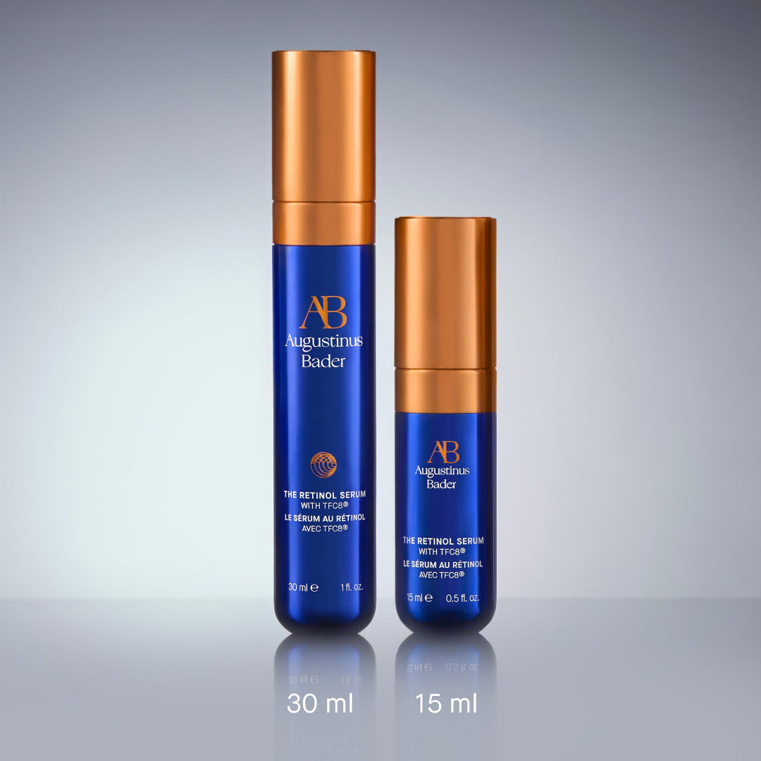 Two blue skincare serum bottles with gold caps on a gray background