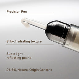 Close-up of a cosmetic applicator pen with a clear tip and black cap, shown on a light gray background with descriptive text callouts about precision, silky hydrating texture, subtle light reflecting pearls, and 96.6% natural origin content.
