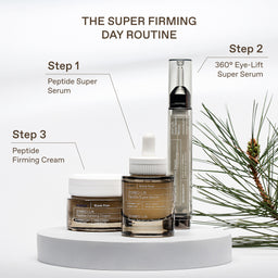 Three skincare products from SKIN1005 are displayed on a white pedestal with instructional text labels for a 'Super Firming Day Routine' against a clean white background with pine branches.