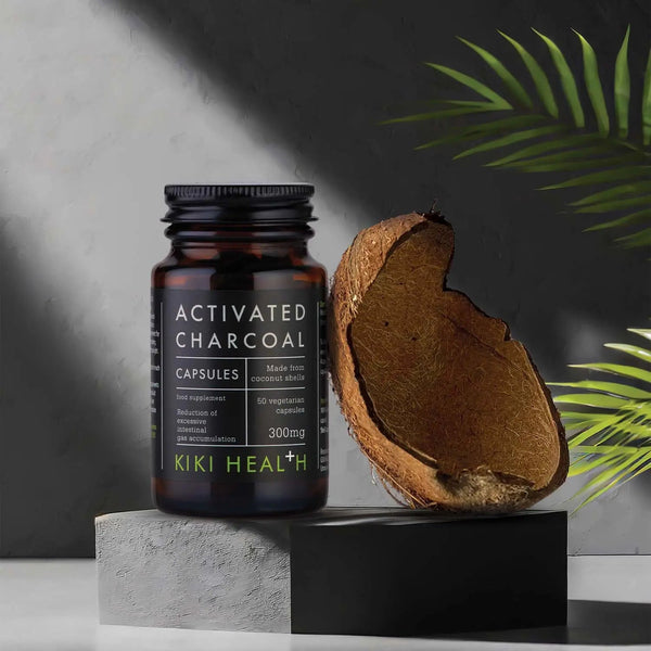 Kiki Health activated charcoal capsules with a coconut on a dark background