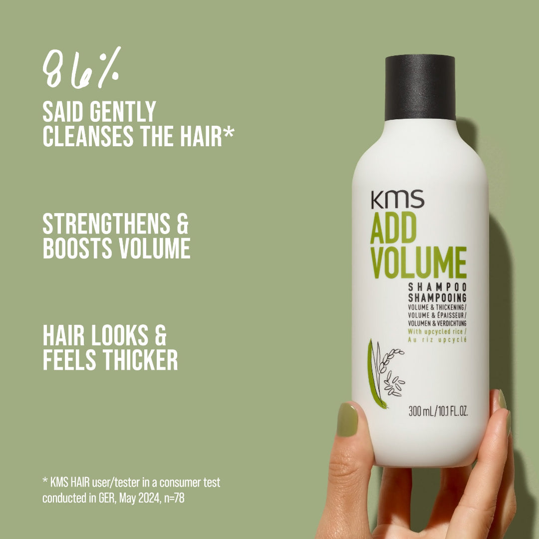KMS Add Volume shampoo bottle held by a hand with product features on a green background