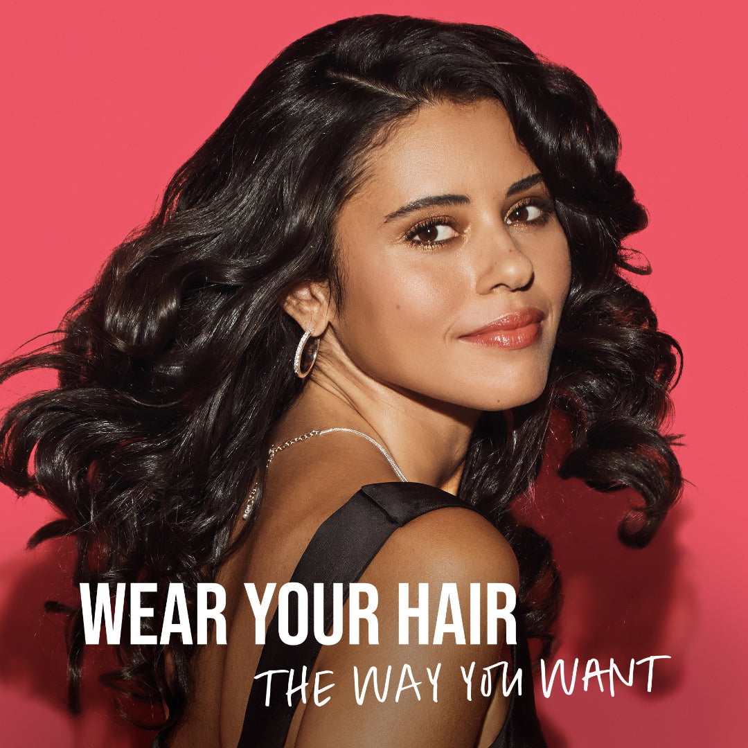 Woman with styled hair against a pink background with text 'Wear Your Hair The Way You Want'.