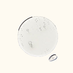 Close-up of clear liquid droplets on a white background