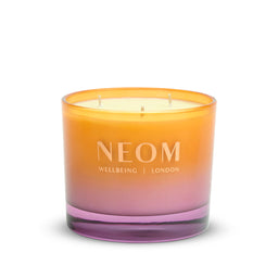 Neom candle with gradient orange to pink design on a white background