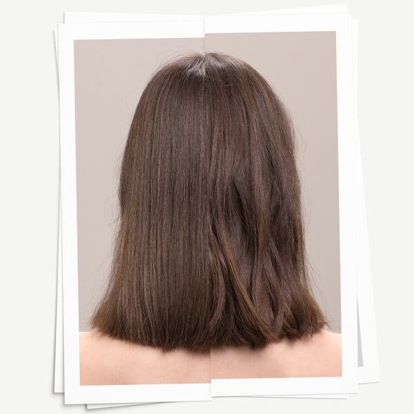 Back view of a person with long, straight brown hair on a neutral background