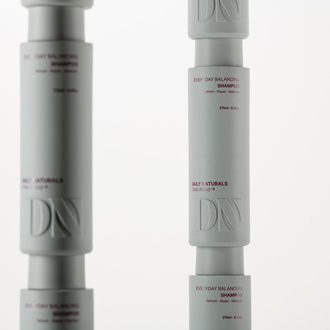 Two bottles of Daily Naturals shampoo on a white background