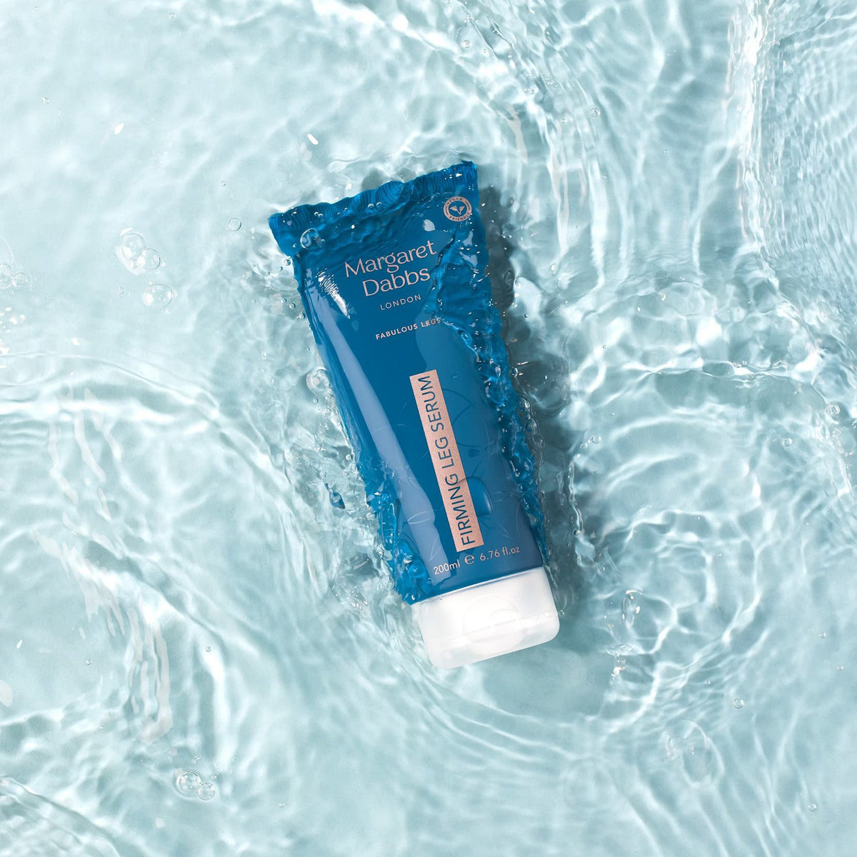 Blue tube of Margaret Dabbs Firming Leg Serum on water surface