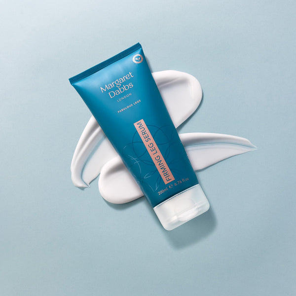Blue tube of Margaret Dabbs Firming Leg Serum on a light blue background