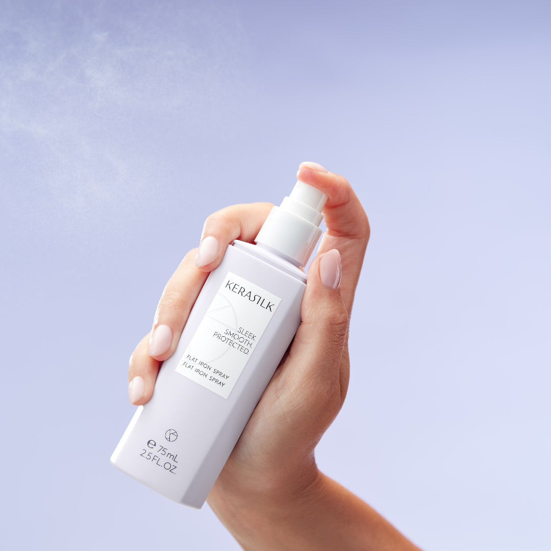 Hand holding a Kerastilk hair product against a light purple background