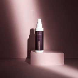 Skincare bottle on a pink platform with a soft pink background