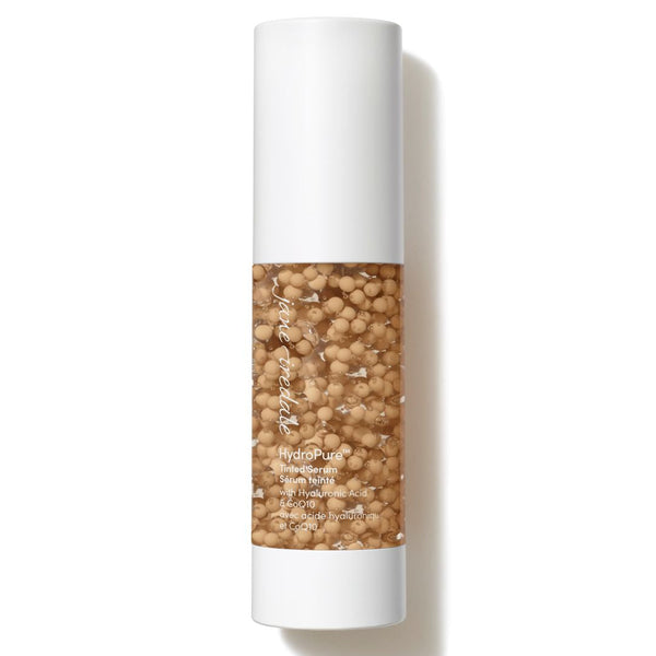 Skincare bottle with a white cap and clear body containing beads on a white background