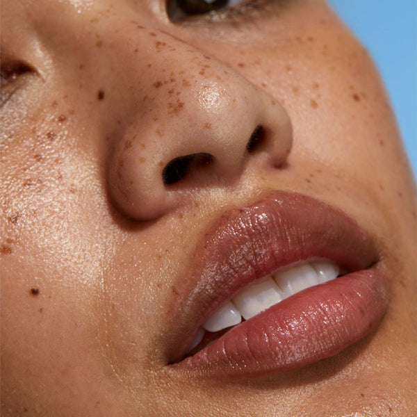 Close-up of a person's face with a clear blue sky background