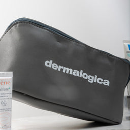Dermalogica pouch on a white surface with a tube of cream next to it.