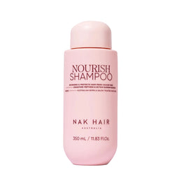 Pink shampoo bottle labeled 'Nourish Shampoo' by NAK Hair on a white background