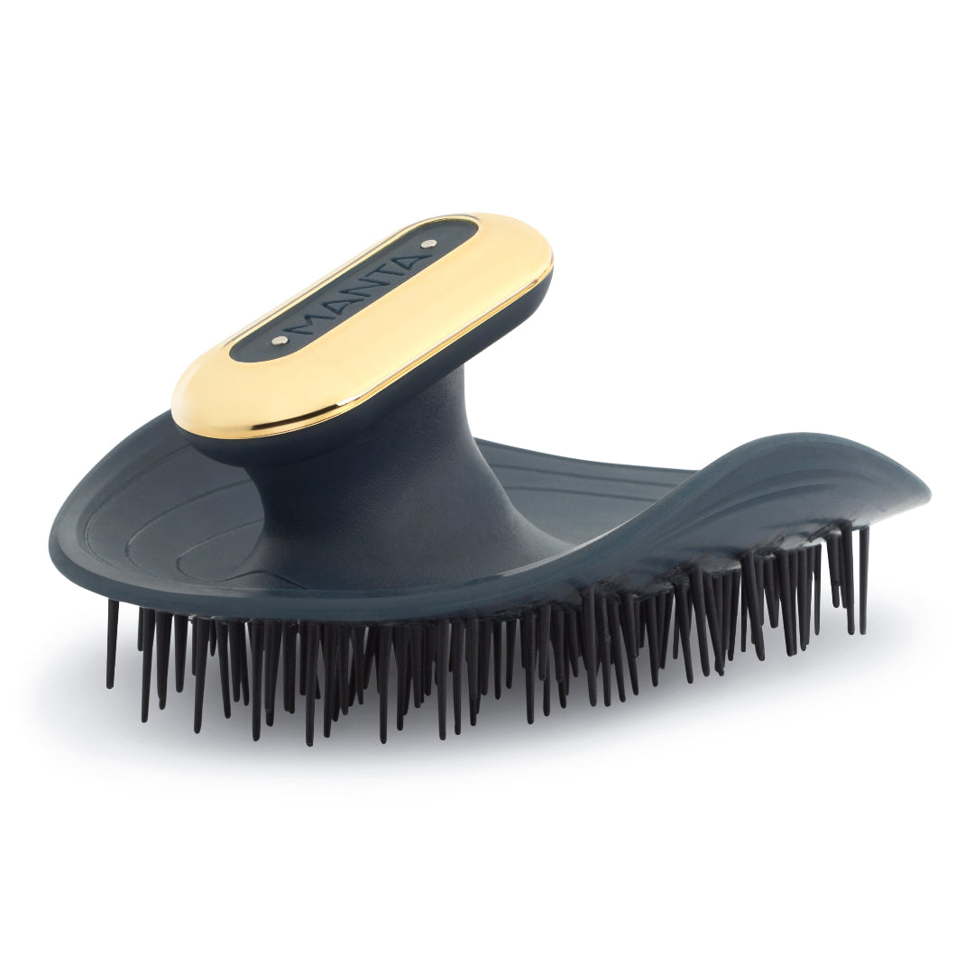 Pet grooming brush with gold and black design on a white background