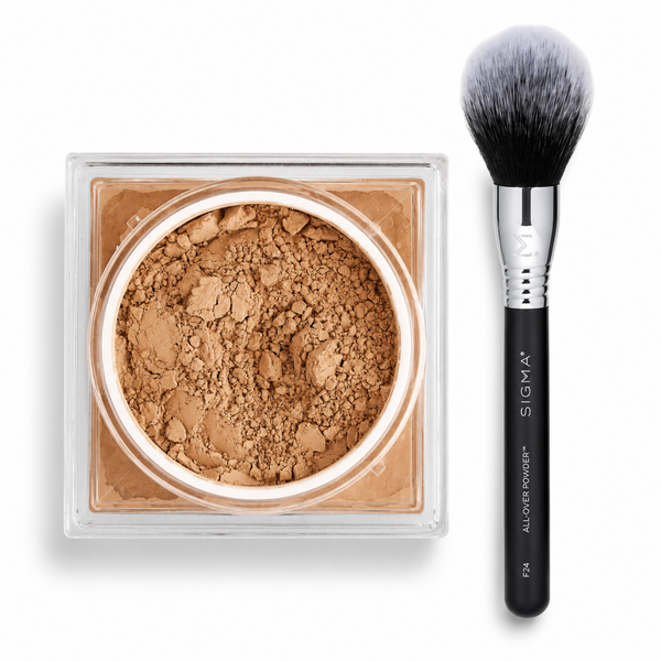 Sigma All Over Powder foundation in a clear square compact next to a black Sigma makeup brush on a white background.
