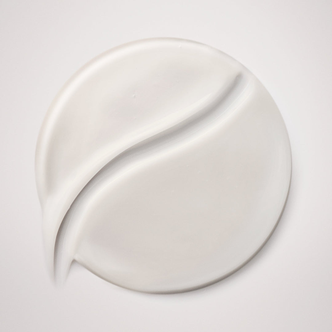 White cream smear on a light gray background
