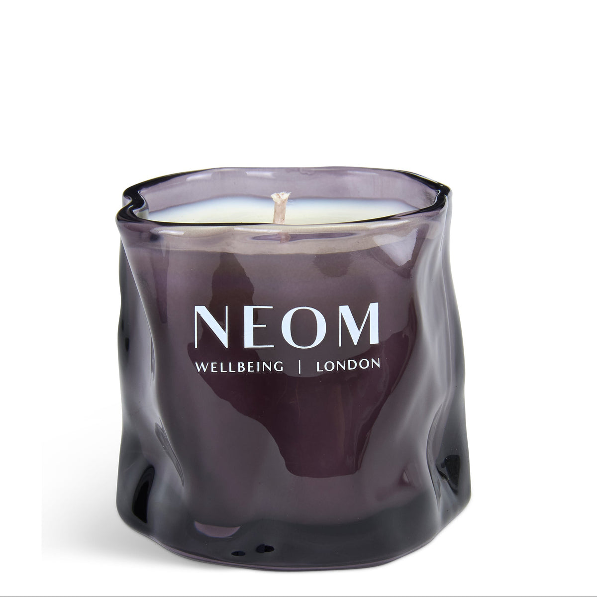 A dark purple glass jar candle with a wavy, organic shape and white wax inside, featuring the brand name 'NEOM' printed in white on the front, set against a plain white background.