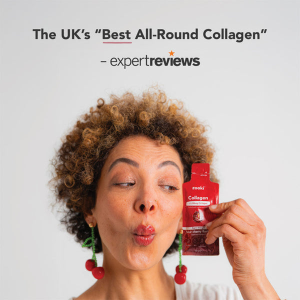 Woman holding a red collagen supplement packet with 'Expert Reviews' text on a light gray background