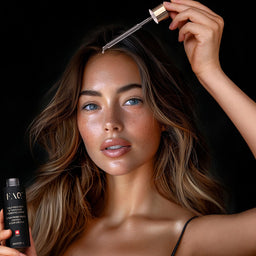 Woman holding a dropper and bottle with a dark background