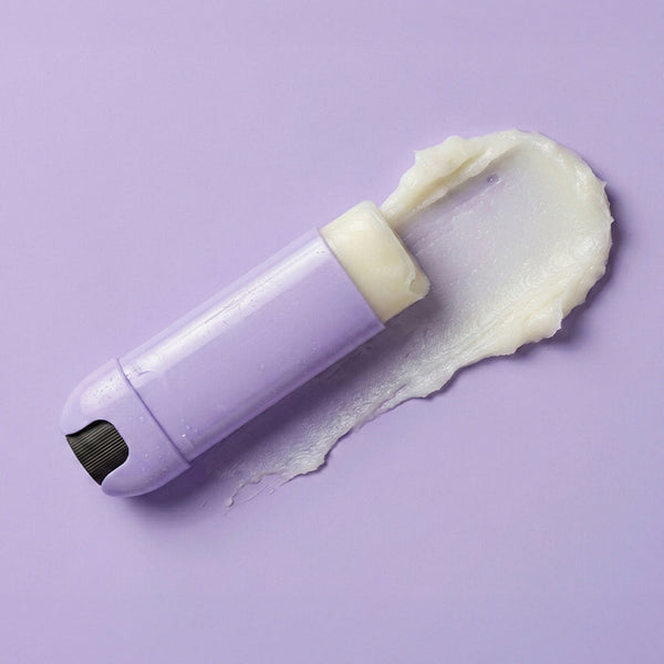 White grooming tool with cream on a purple background