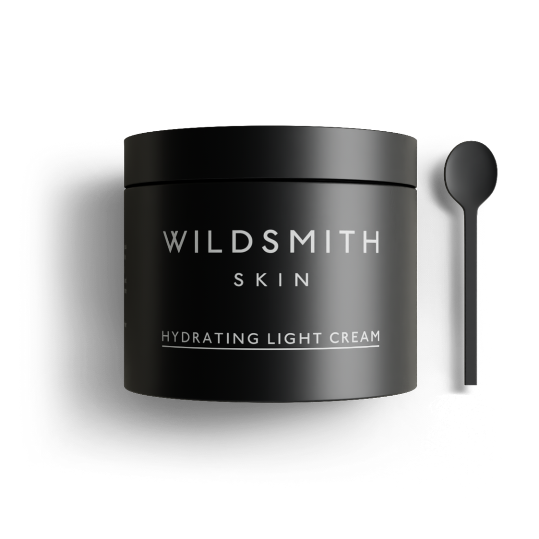 Black jar of Wildsmith Skin hydrating light cream with a spoon on a white background