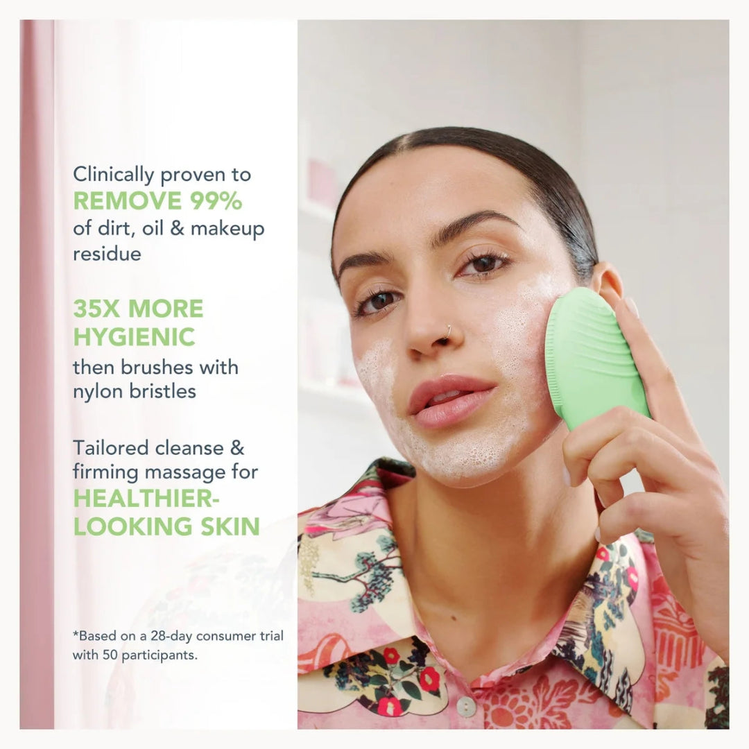 A woman with white cleanser foam on her face holds a mint green cleansing brush against her cheek. The left side features promotional text highlighting the product's clinical efficacy, 99% dirt, oil, and makeup residue removal, and 35x more hygienic nylon bristles.