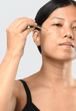 a women applying Minimalist Niacinamide 05% to her cheek 