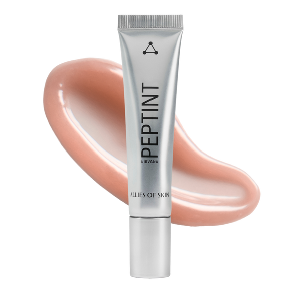 A silver squeeze tube of PEPTINT by Clés de Skin, set against a glossy peach-colored cosmetic swatch on a solid white background.
